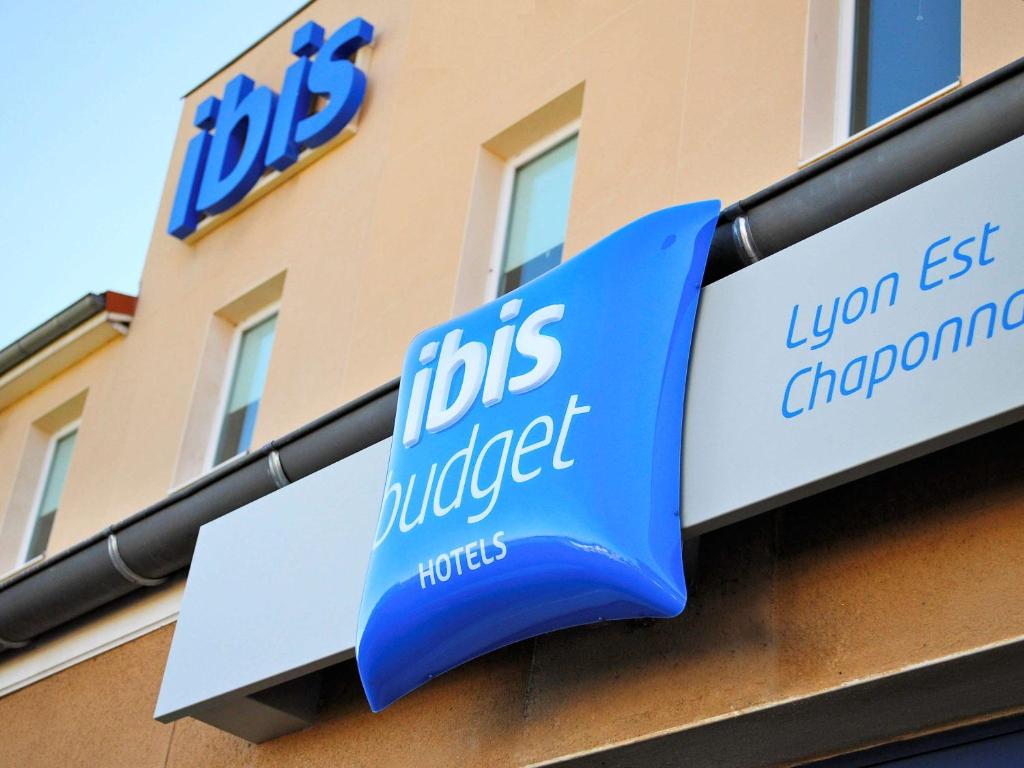 niebiesko-biały znak na boku budynku w obiekcie ibis budget Lyon Est Chaponnay w mieście Chaponnay