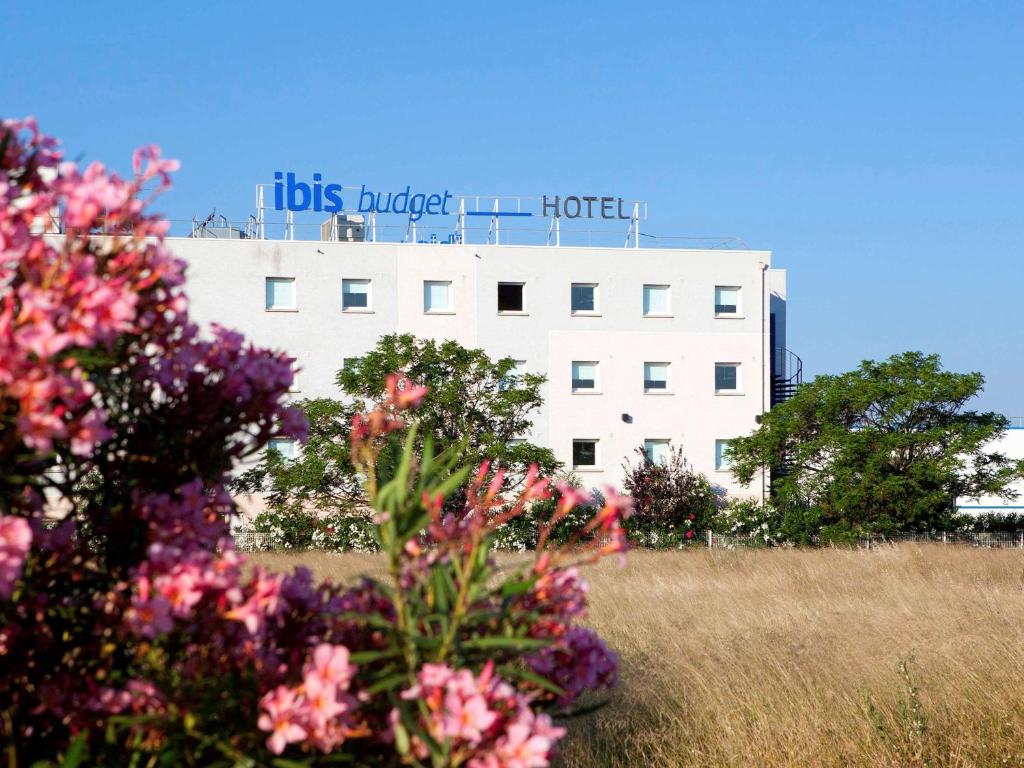 Un bâtiment avec un panneau en haut dans l'établissement ibis budget Narbonne Est, à Narbonne