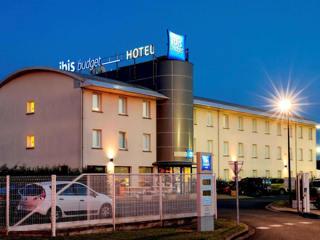 un hotel con un coche aparcado delante de él en ibis budget Meung sur Loire, en Meung-sur-Loire