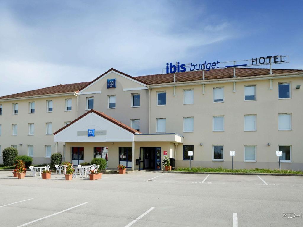 a hotel with a parking lot in front of it at Ibis Budget Dole-Choisey in Dole