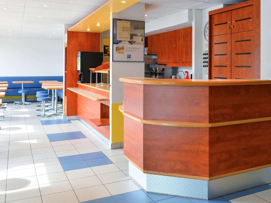 a kitchen with wooden cabinets and a counter top at Ibis budget Orléans Sud Comet in Orléans