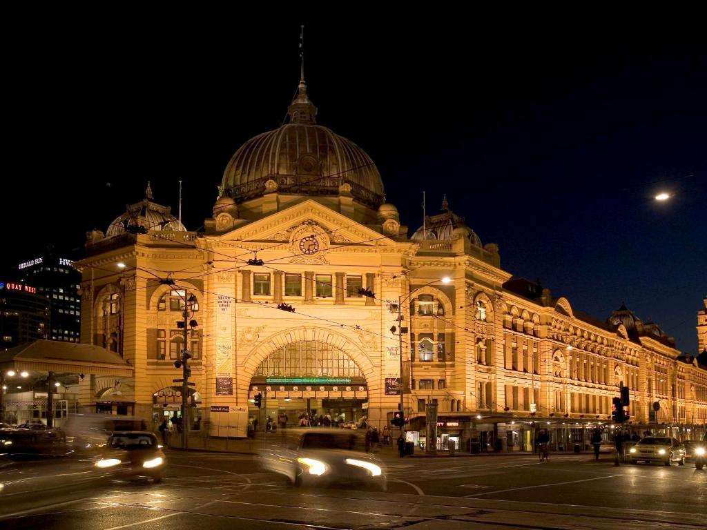 un gran edificio con coches pasando por delante por la noche en ibis Budget - Melbourne CBD en Melbourne