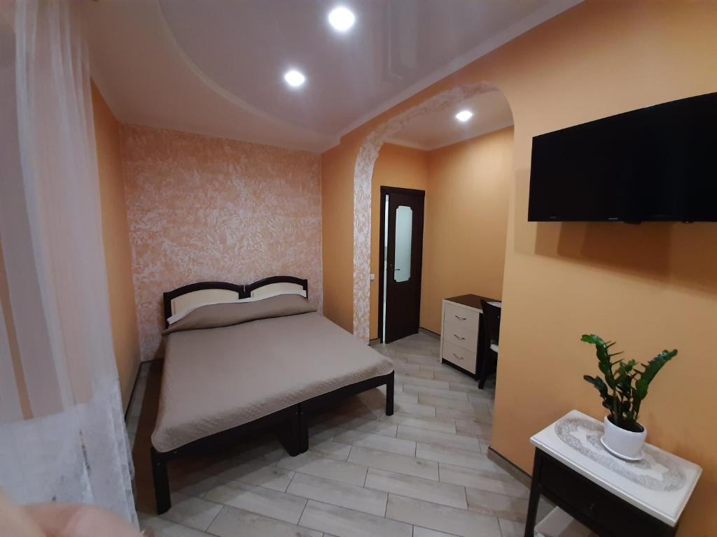 1 dormitorio con 1 cama y TV de pantalla plana en Mini-hotel en Umanʼ