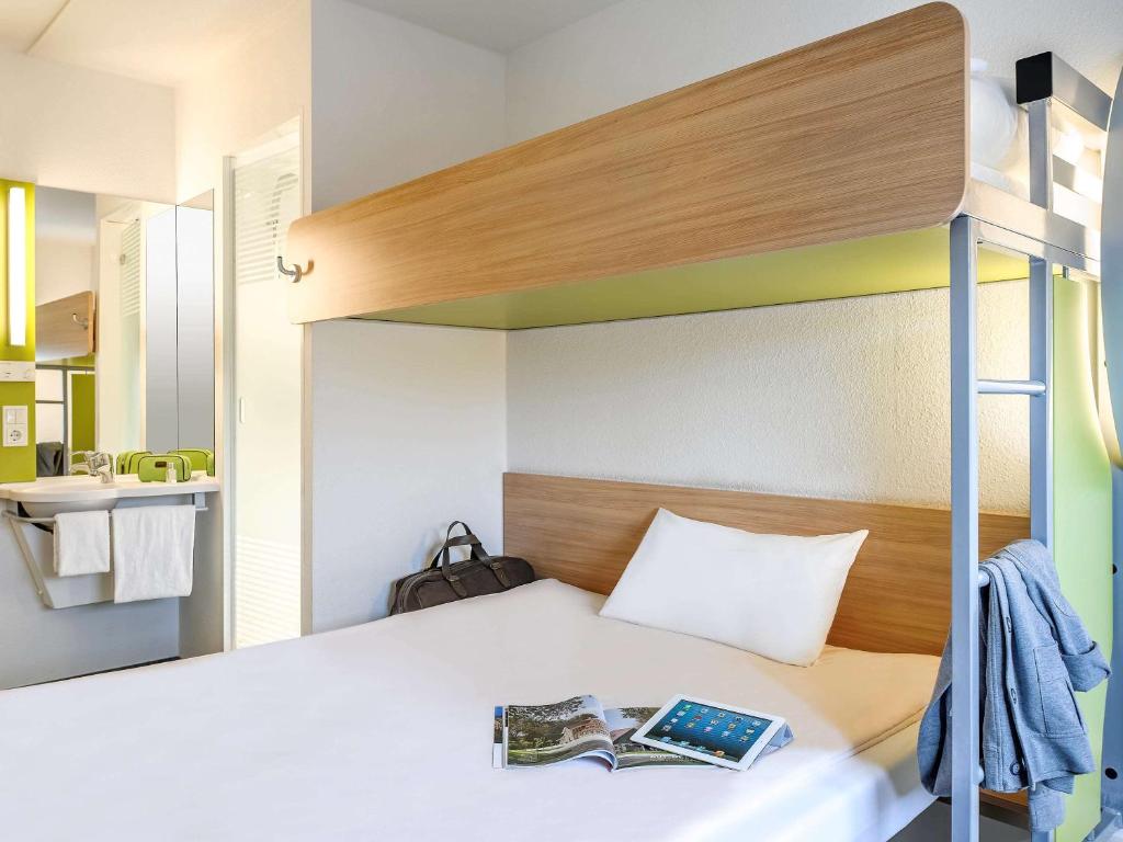 a bedroom with a bunk bed with a book on it at Hotel Ibis Budget Cosne Sur Loire in Cosne-Cours-sur-Loire