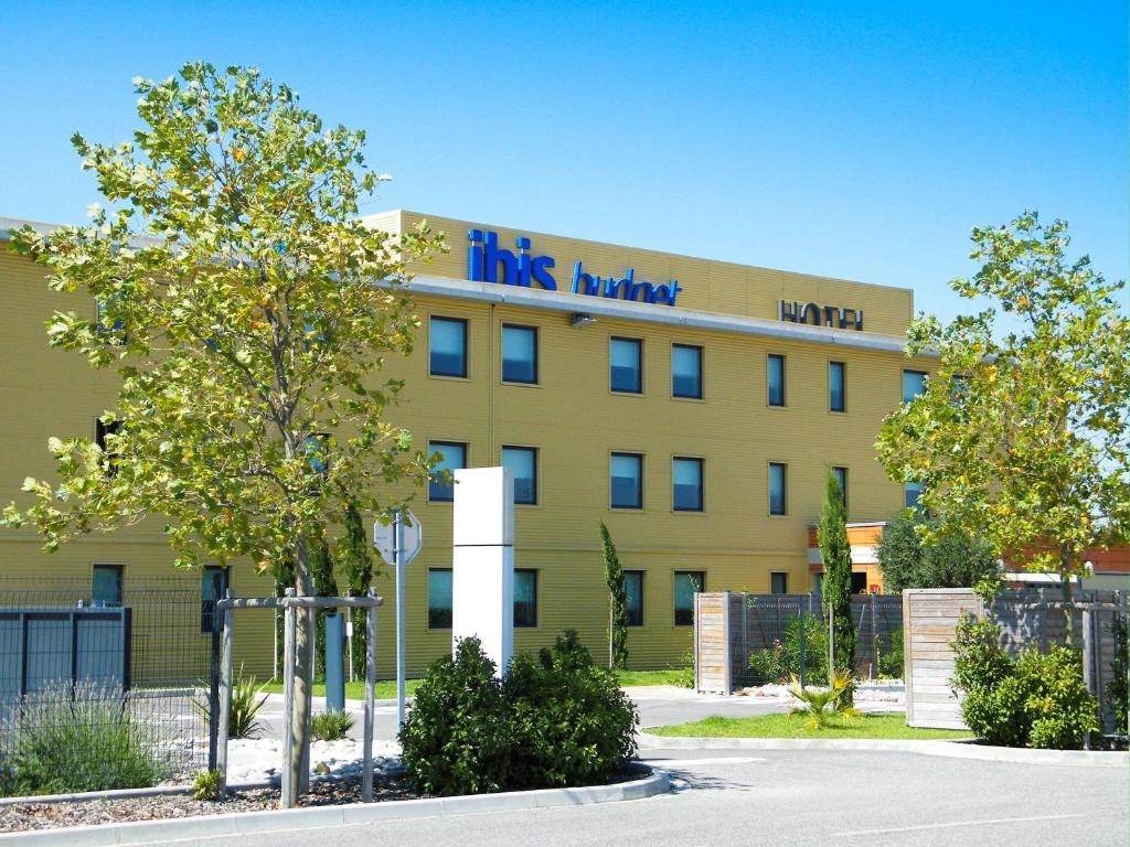 a large yellow building with a sign on it at ibis budget Castelnaudary - A61 in Castelnaudary