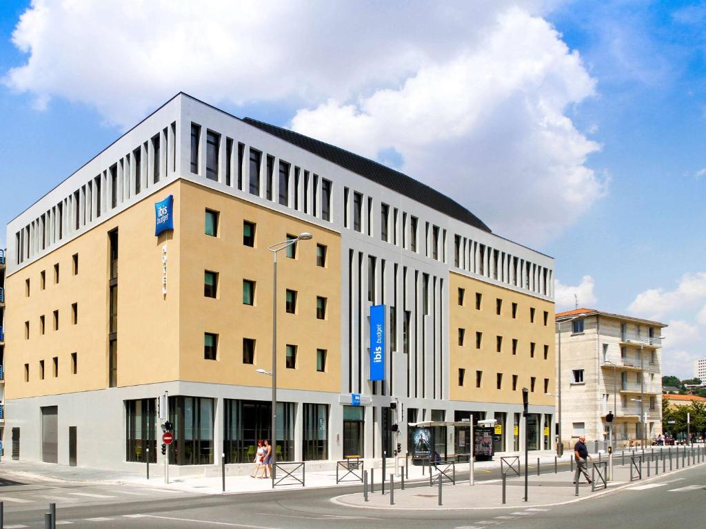 un grand bâtiment au coin d'une rue dans l'établissement ibis budget Gare de Poitiers, à Poitiers