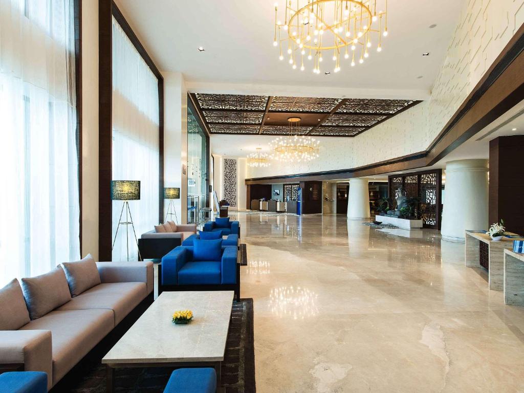 a lobby with couches and chairs and a chandelier at Novotel Imagicaa Khopoli in Khopoli