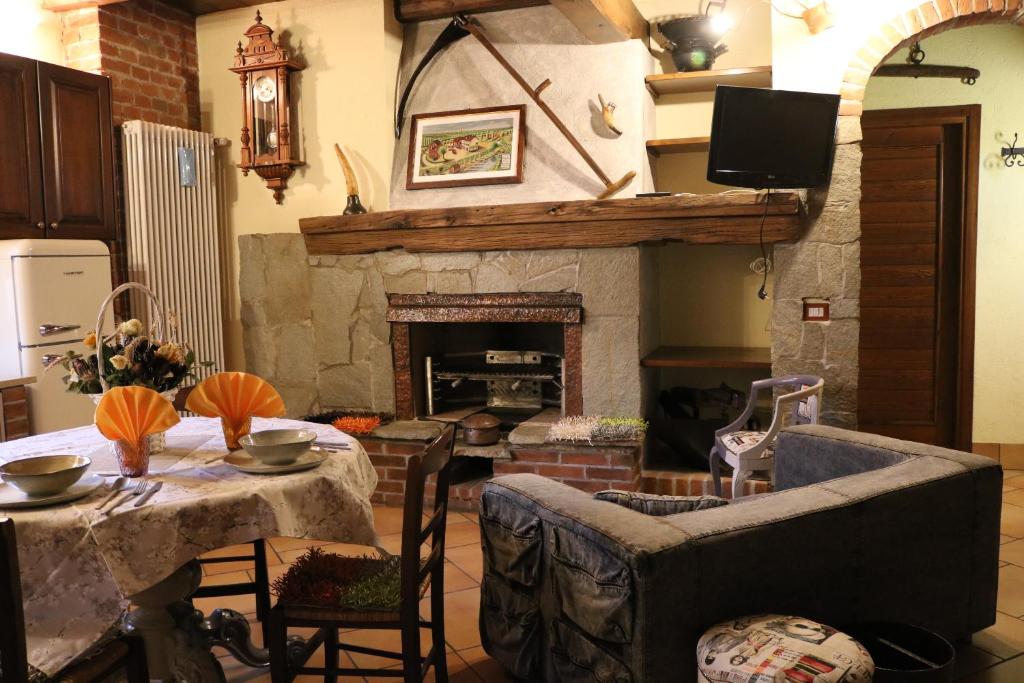 sala de estar con mesa y chimenea en Cascina Merlanetta, en Alessandria
