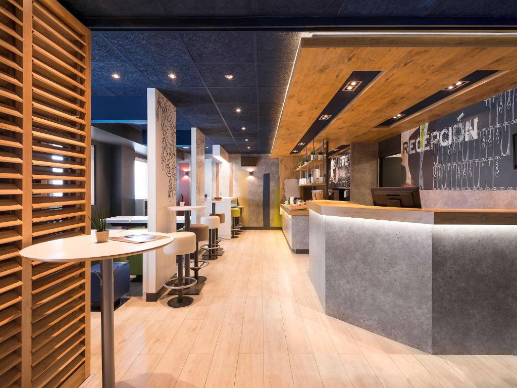 a restaurant with a bar with tables and chairs at Ibis Budget Bilbao Barakaldo in Barakaldo