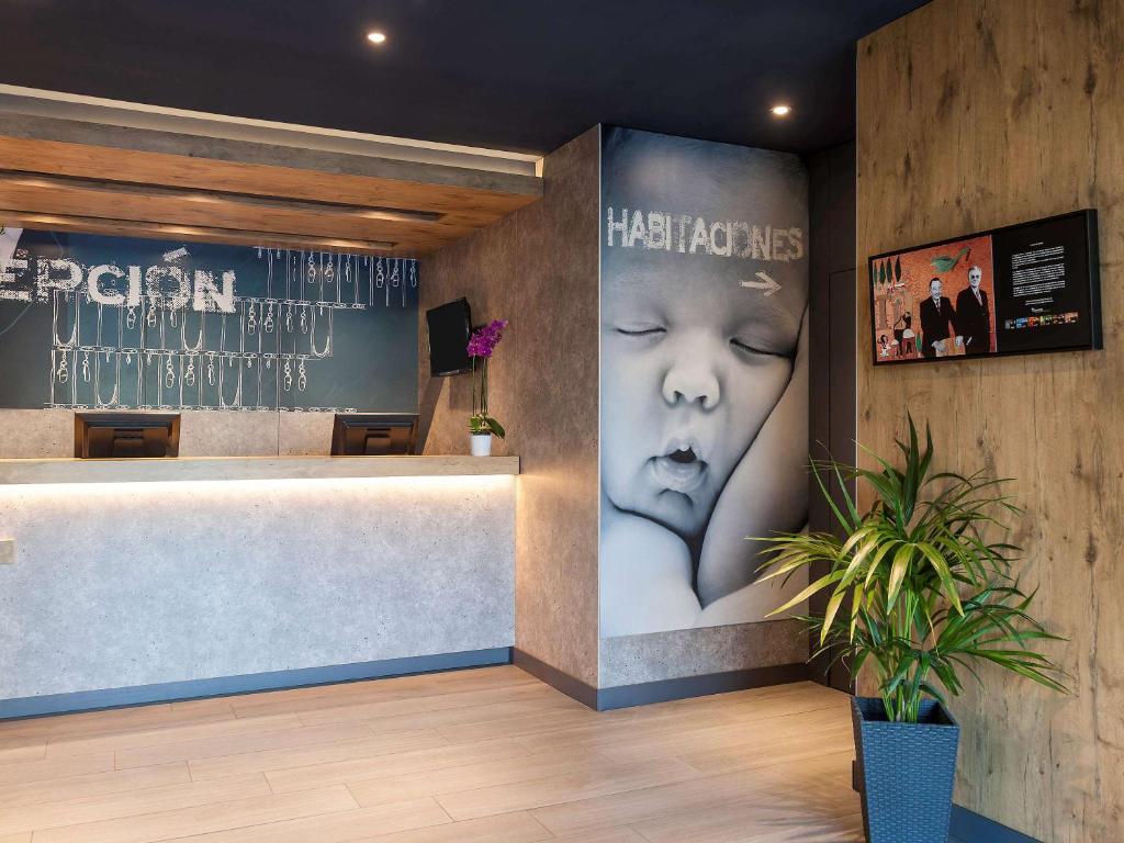 a lobby with a picture of a child on the wall at Ibis Budget Madrid Calle 30 in Madrid