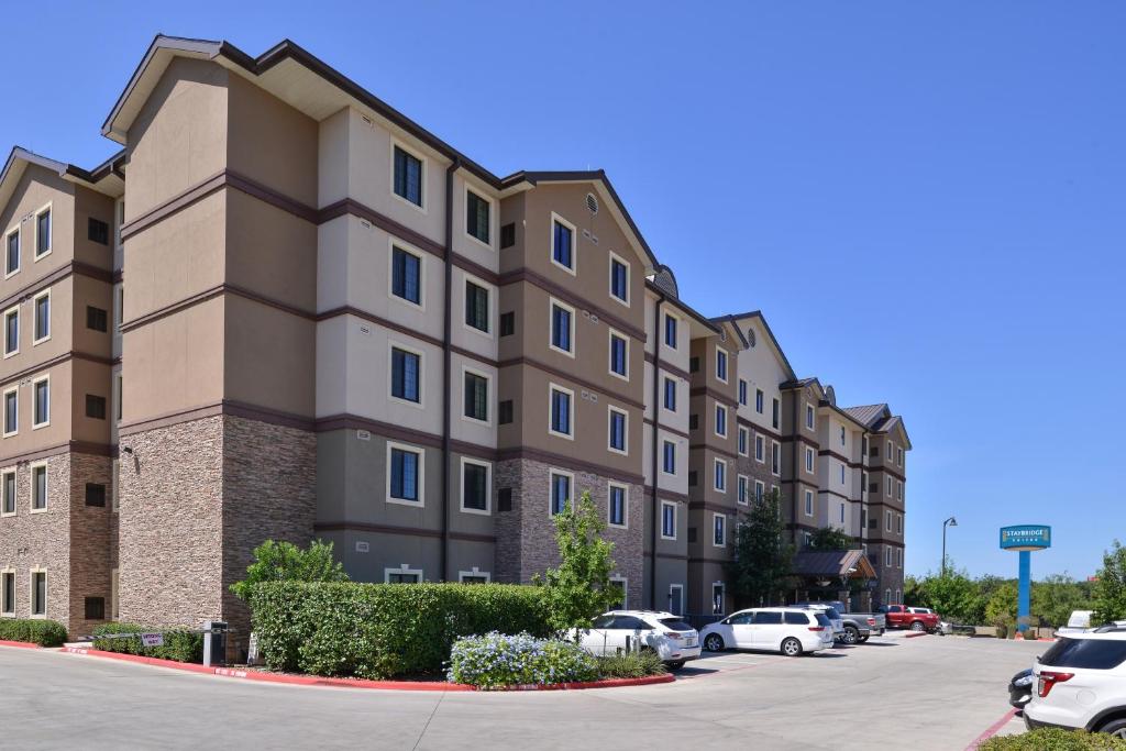 um edifício com carros estacionados num parque de estacionamento em Staybridge Suites San Antonio-Stone Oak, an IHG Hotel em San Antonio