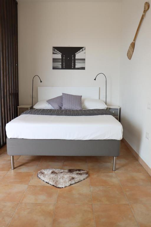 1 dormitorio con cama y alfombra en el suelo en Myricae en Viareggio