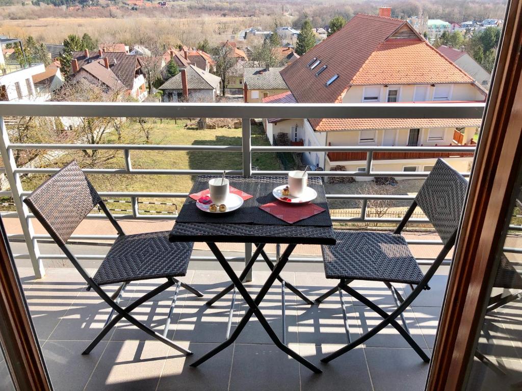einen Tisch und Stühle auf einem Balkon mit Aussicht in der Unterkunft Savelij apartament in Hévíz