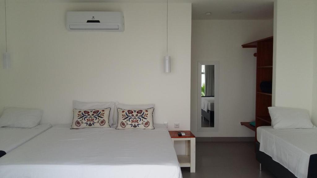 a bedroom with two beds and a table with a window at KiteBar Hotel in Cumbuco
