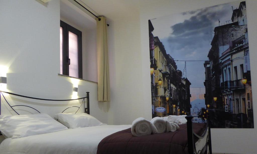 una camera da letto con un letto e asciugamani di I Giganti a Cagliari