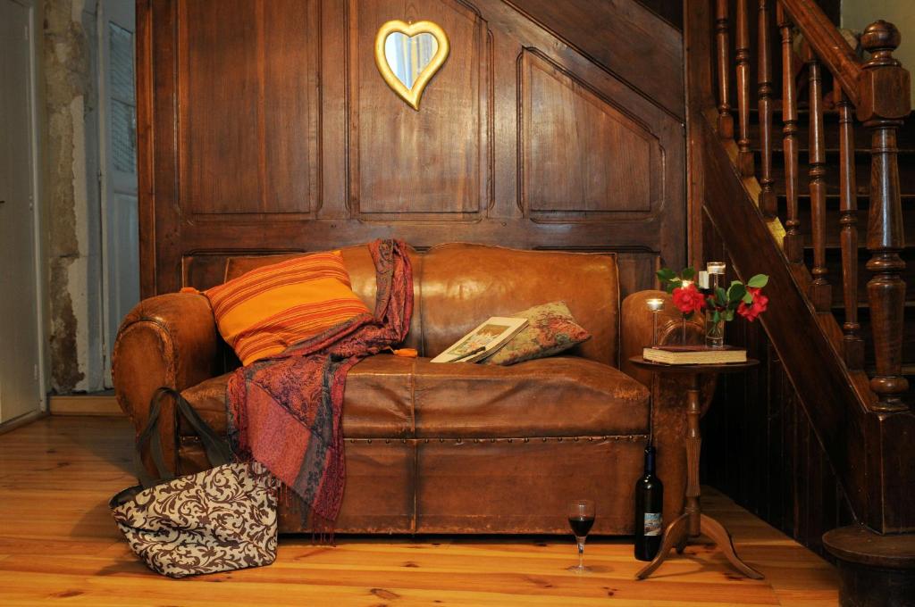 MontolieuにあるMaison Rives - Village du Livre de Montolieuの壁のある部屋に座る茶色の革張りのソファ