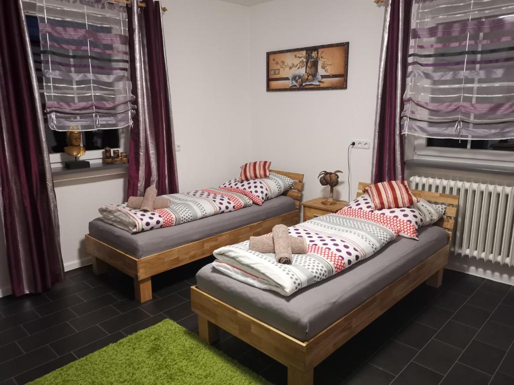 two beds in a room with red and white pillows at byJoe in Morschen