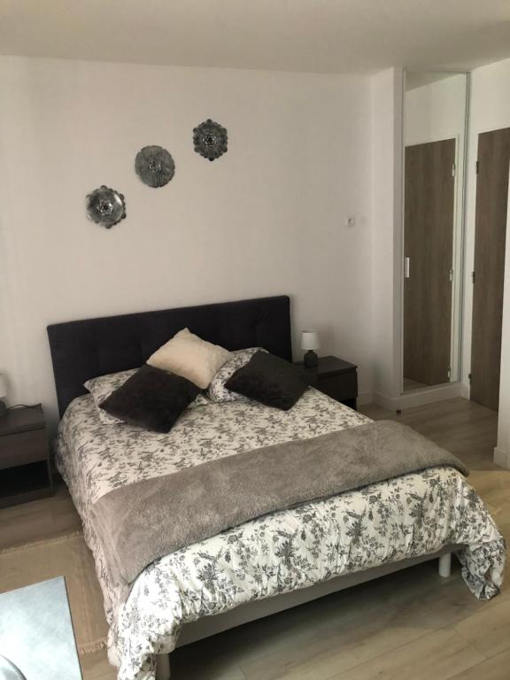 um quarto com uma cama com um edredão e almofadas em Casa SM em Mennecy