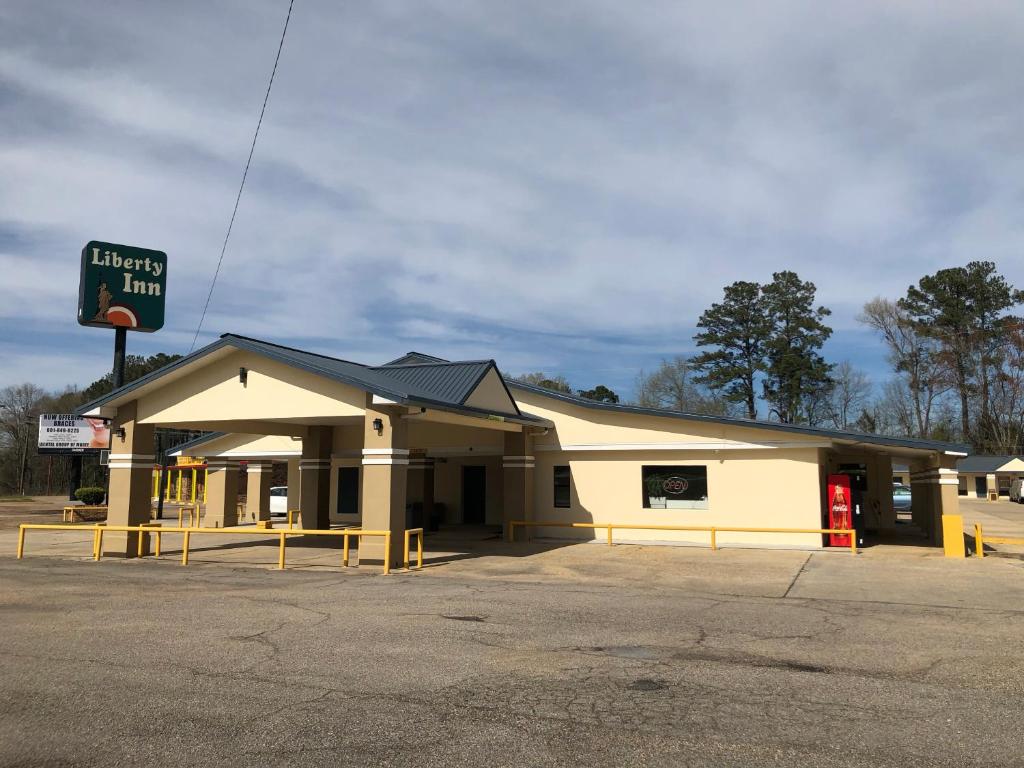 um posto de gasolina com um sinal em cima dele em Liberty Inn - Collins em Collins