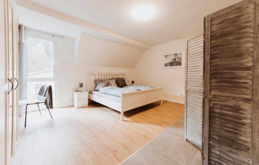 a white bedroom with a bed and a window at Pension Dorotheenhof in Leun
