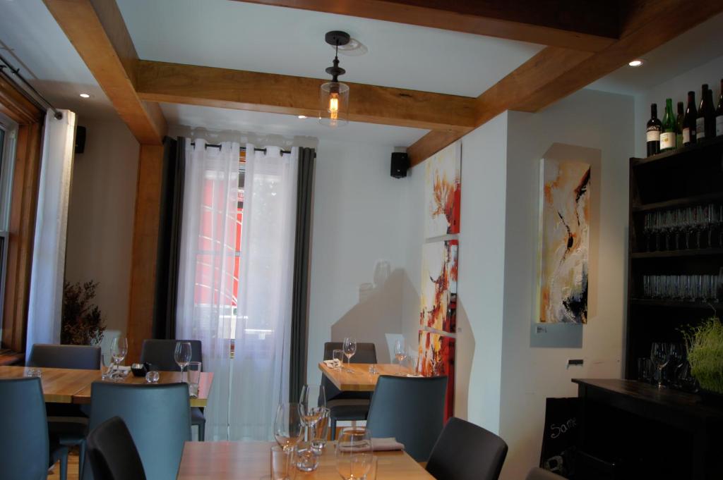 a dining room with tables and chairs and a window at Restaurant et Gite Les Passionnés in Val-David