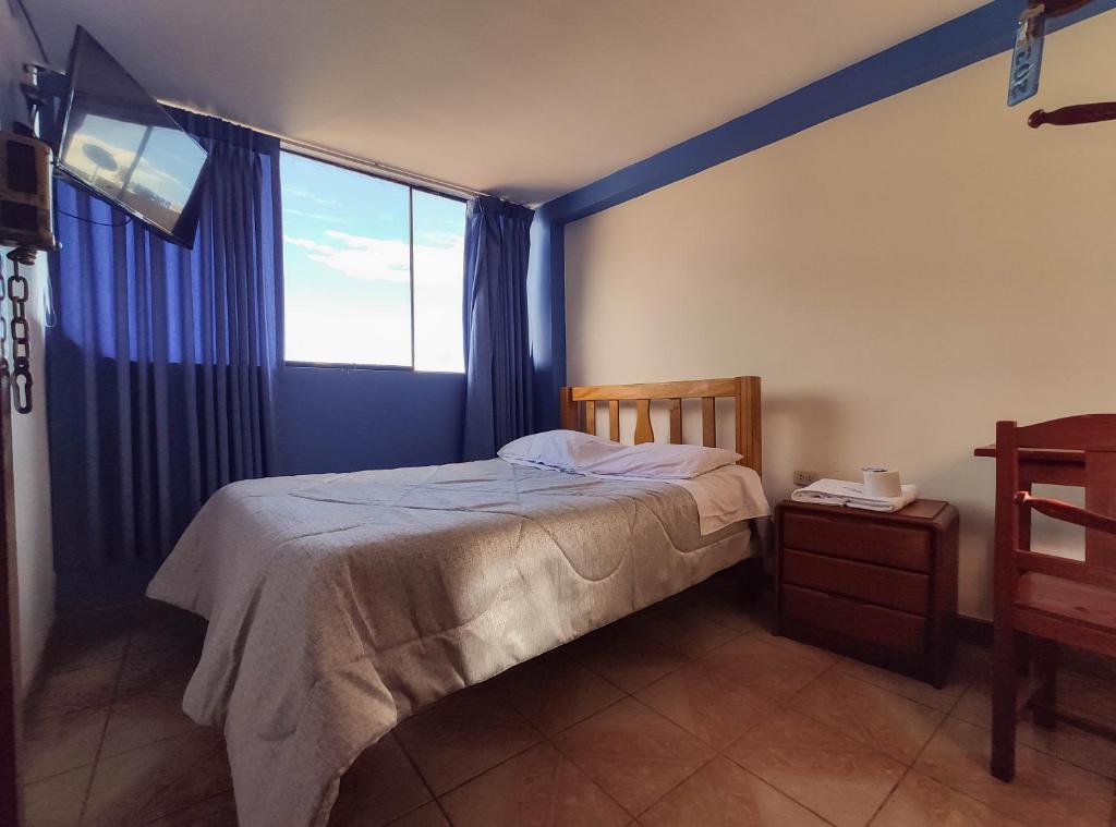 een slaapkamer met een bed en een groot raam bij Hospedaje Manchego's in Huancayo