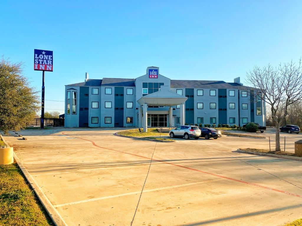 ein blaues Gebäude mit einem Auto auf einem Parkplatz in der Unterkunft Lone Star Inn in Decatur