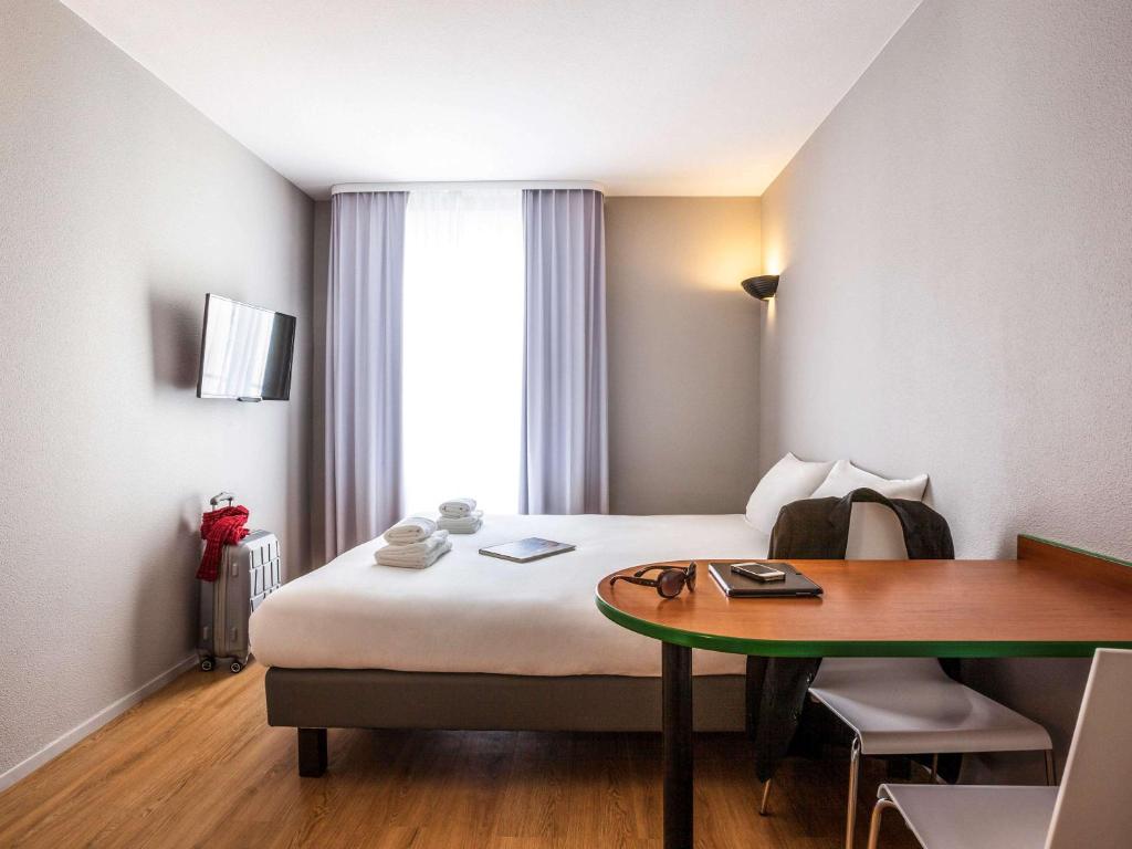 um quarto de hotel com uma cama e uma mesa em Aparthotel Adagio Access Paris Maisons-Alfort em Maisons-Alfort