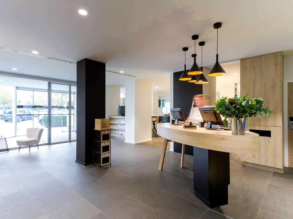 a living room with a desk and a kitchen at ibis Styles Kortrijk Expo in Kortrijk