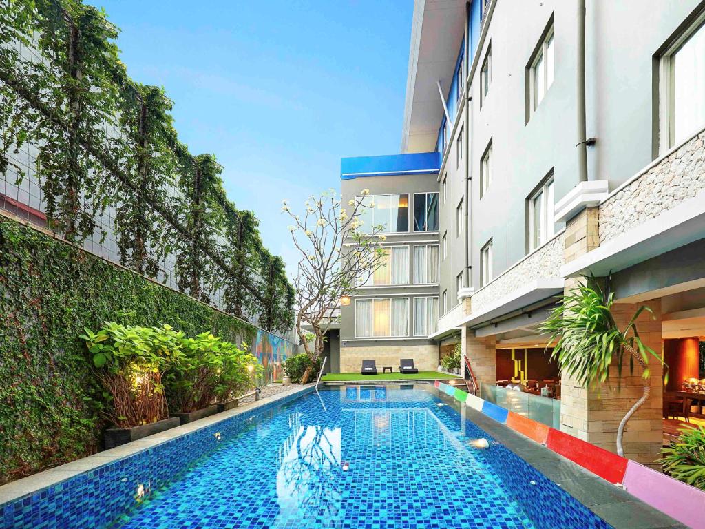 a swimming pool in the middle of a building at Primera Hotel Seminyak in Seminyak
