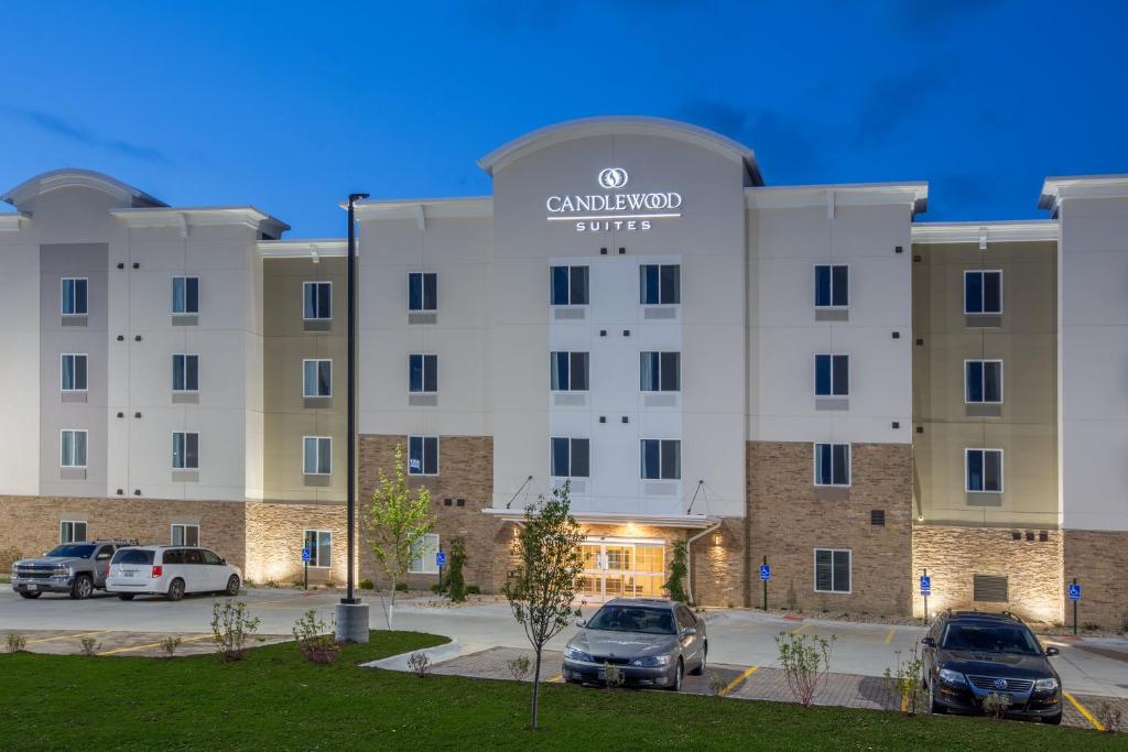 un gran edificio con coches estacionados en un estacionamiento en Candlewood Suites - Omaha Millard Area, an IHG Hotel, en Millard