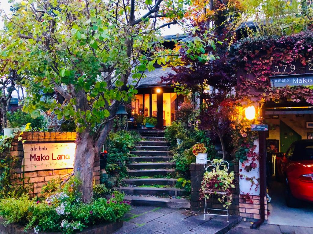 eine Treppe, die zu einem Haus mit Blumen führt in der Unterkunft ガーデンハウス Mako Land in Toyama