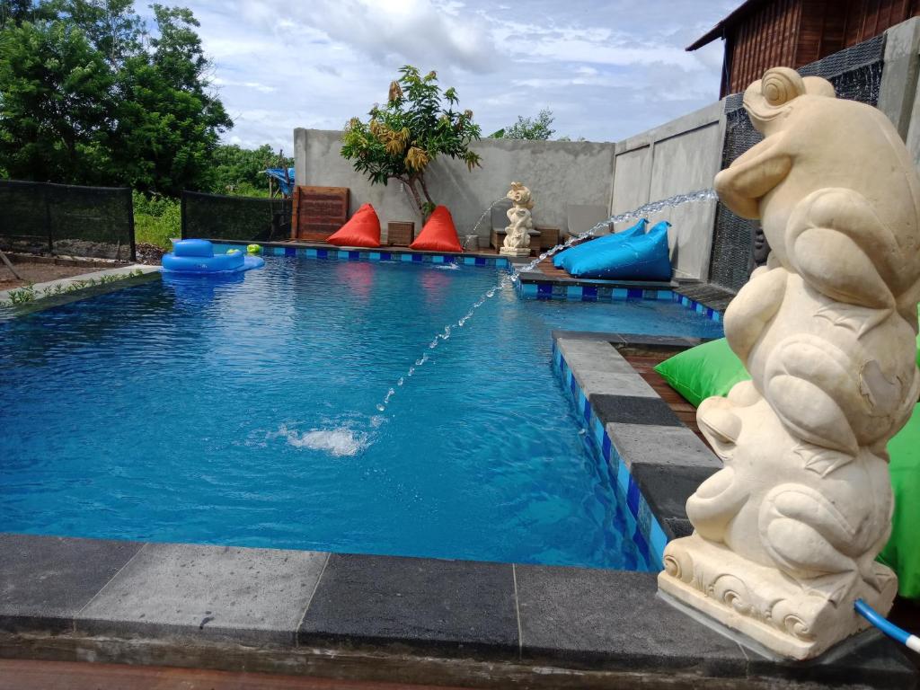a swimming pool with a water slide in a backyard at Devadav Hostel (Bunk Bed) Nusa Lembongan in Nusa Lembongan