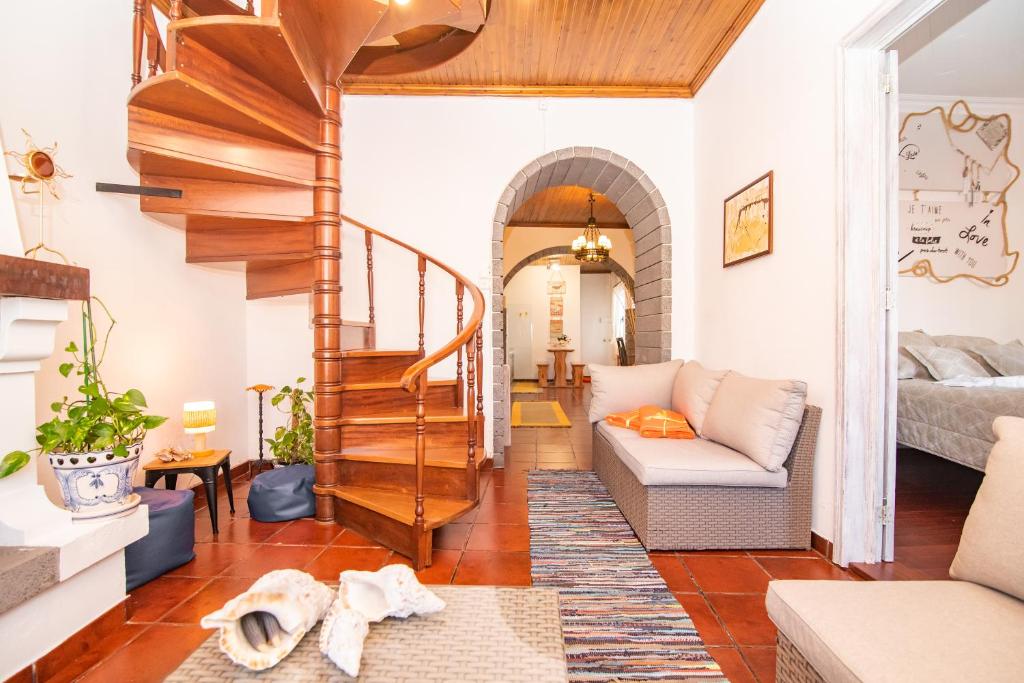 Una sala de estar con una escalera y un sofá. en CASA INTI / INTI HOUSE FURNAS, en Furnas