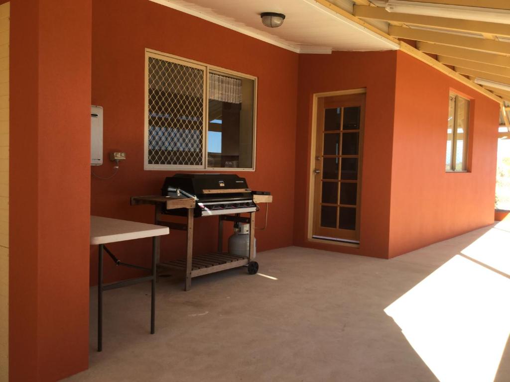an empty room with orange walls and a desk at Caretakers Cottage Budget Accommodation in Denham