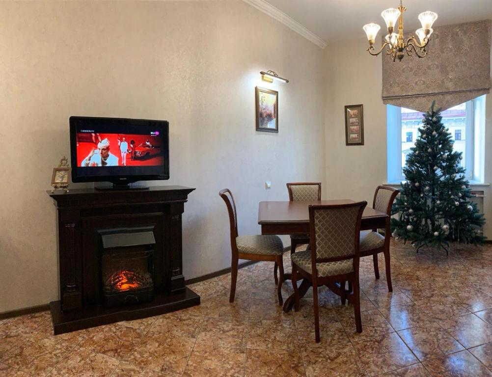 a living room with a table and a television and a christmas tree at Residence Moika River in Saint Petersburg