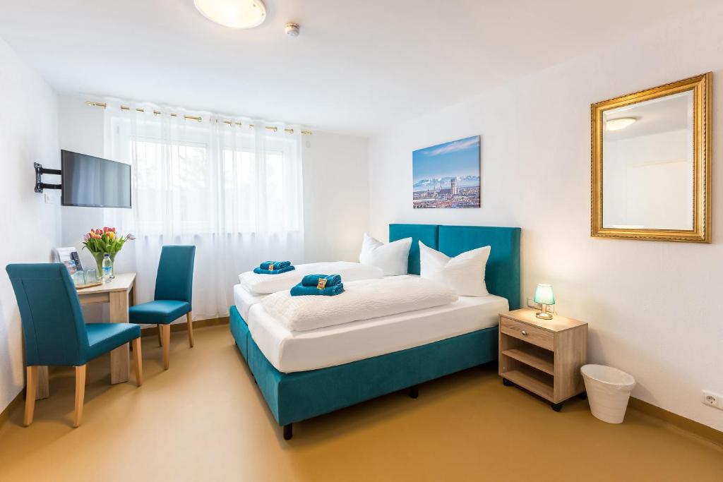 Schlafzimmer mit einem Bett, einem Tisch und Stühlen in der Unterkunft Hotel Ludwig in München