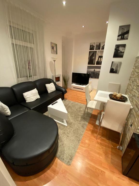 - un salon avec un canapé noir et une table dans l'établissement Dani Apartment, à Rijeka