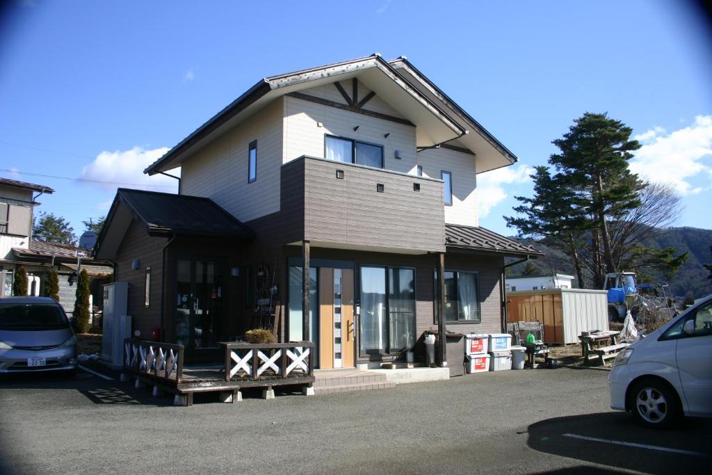 una casa con un coche aparcado delante de ella en Villa May Queen, en Fujikawaguchiko