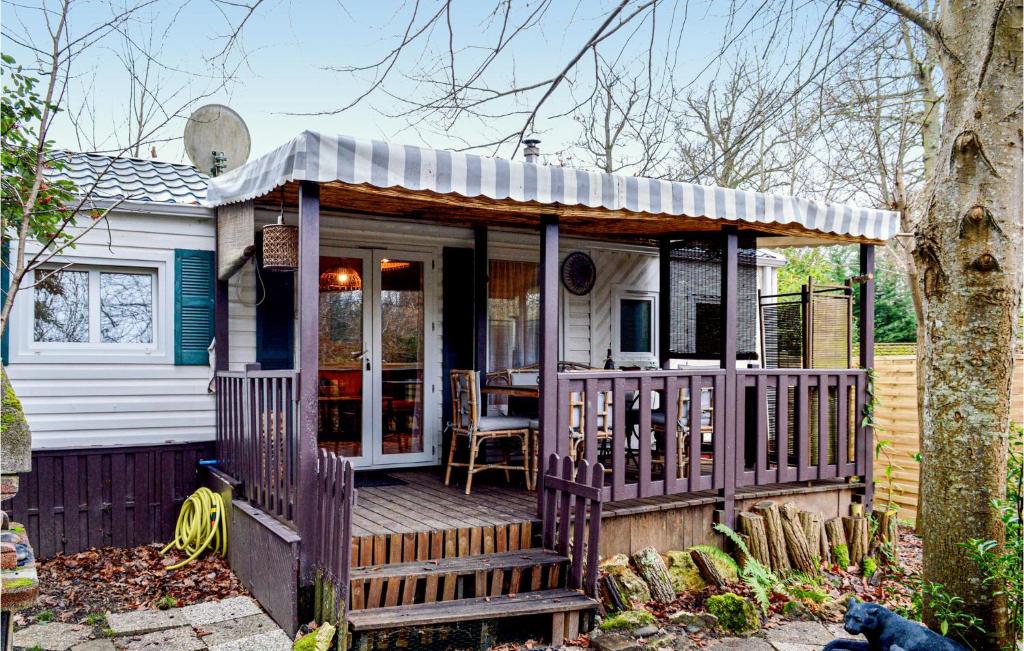 a small house with a porch and a deck at Nice stacaravan In Livry-sur-seine With Wifi in Livry-sur-Seine