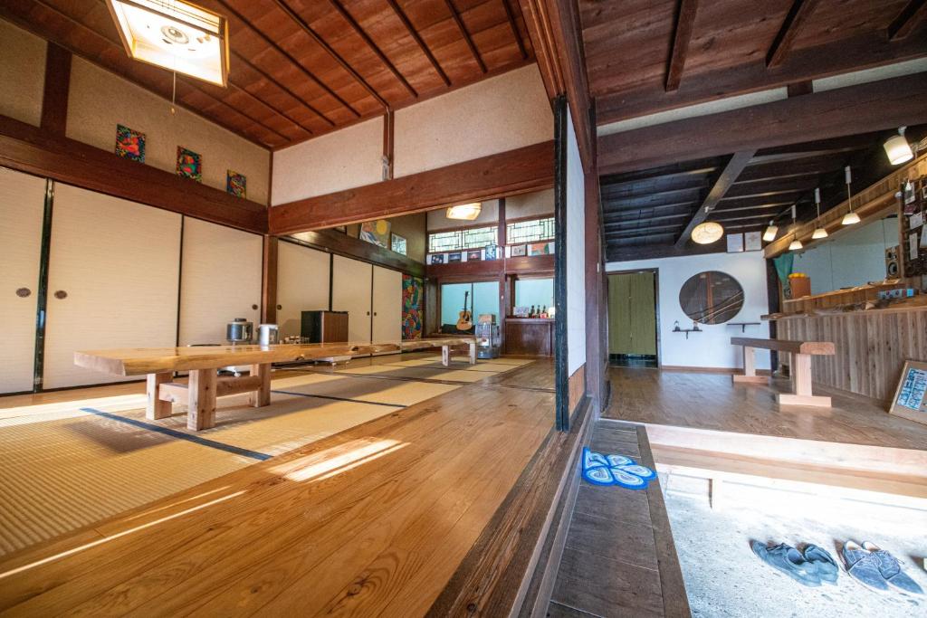 隠岐の島町にある一棟貸し宿Kusuburu House chartered accommodationの木製の床と木製の天井が備わる広い客室です。