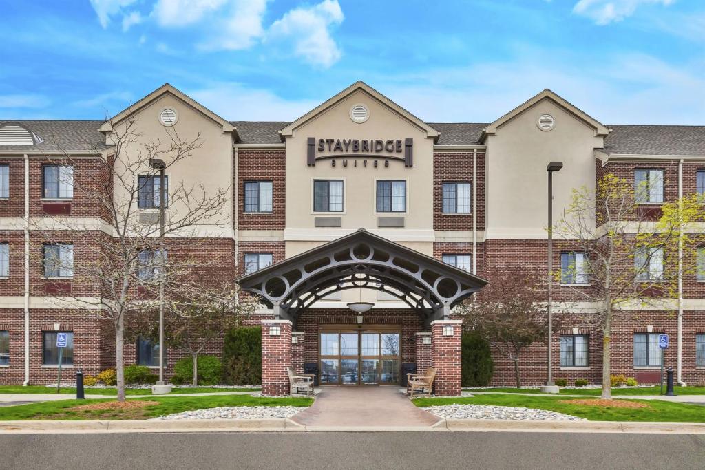 a large brick building with a clock on the front of it at Staybridge Suites Lansing-Okemos, an IHG Hotel in Okemos
