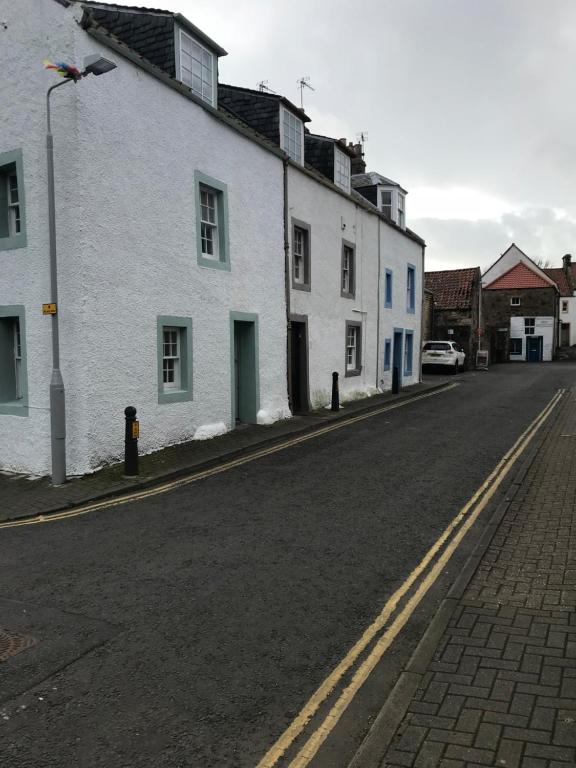 eine leere Straße mit weißen Gebäuden und einem Straßenlicht in der Unterkunft Daisy Cottage in Saint Monance