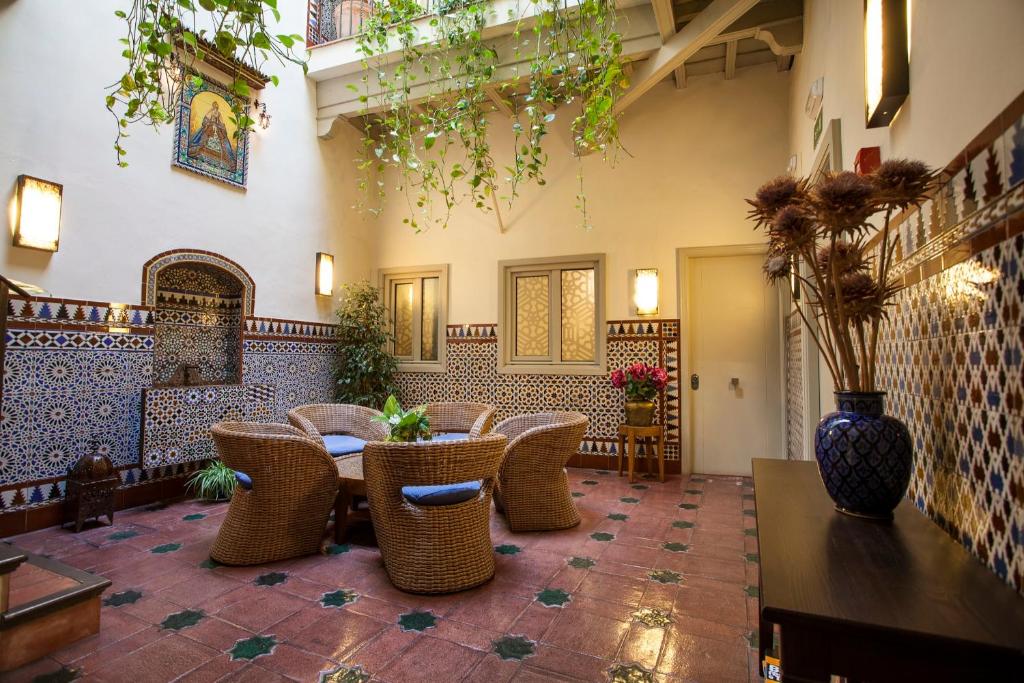 - un hall avec des chaises en osier et une table dans l'établissement Hotel Boutique Casas de Santa Cruz, à Séville