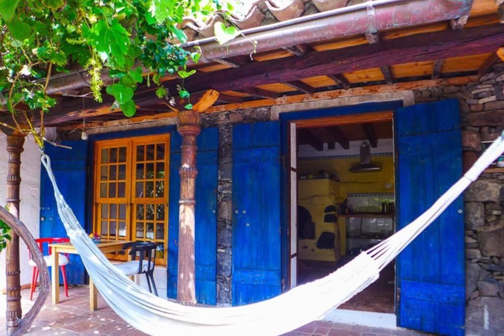 a hammock in front of a blue house at Casa Avocado in Valle Gran Rey