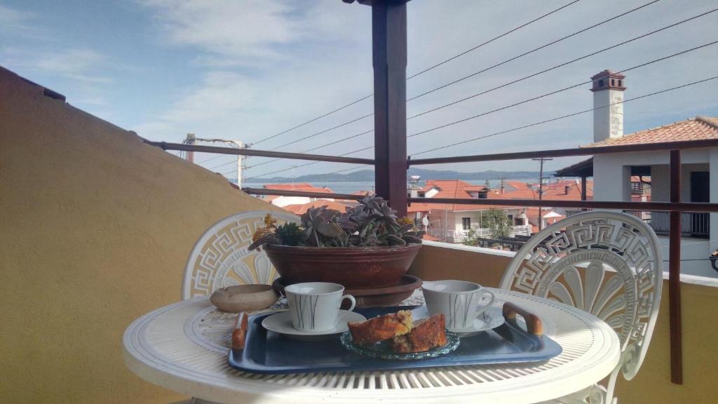 a table with a plate of food on a balcony at Attic of Mary in Nea Roda