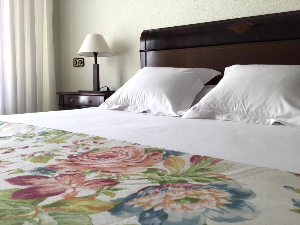 1 dormitorio con 1 cama con manta de flores en Apartamento Tellería con parking gratis, en Barakaldo