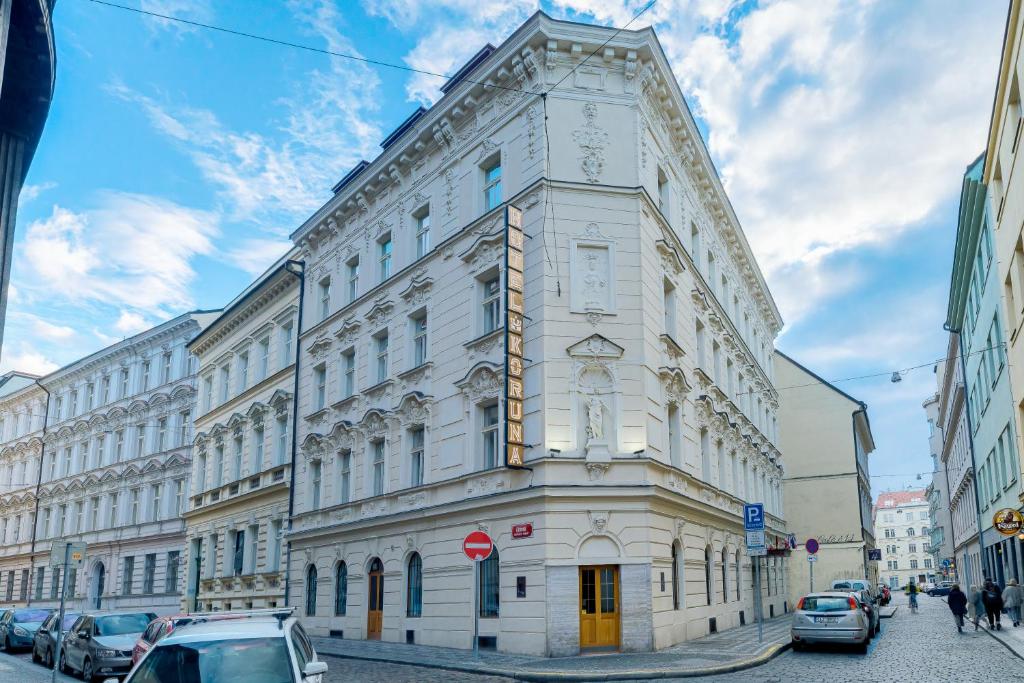 a white building with a clock on the side of it at Koruna Hotel in Prague