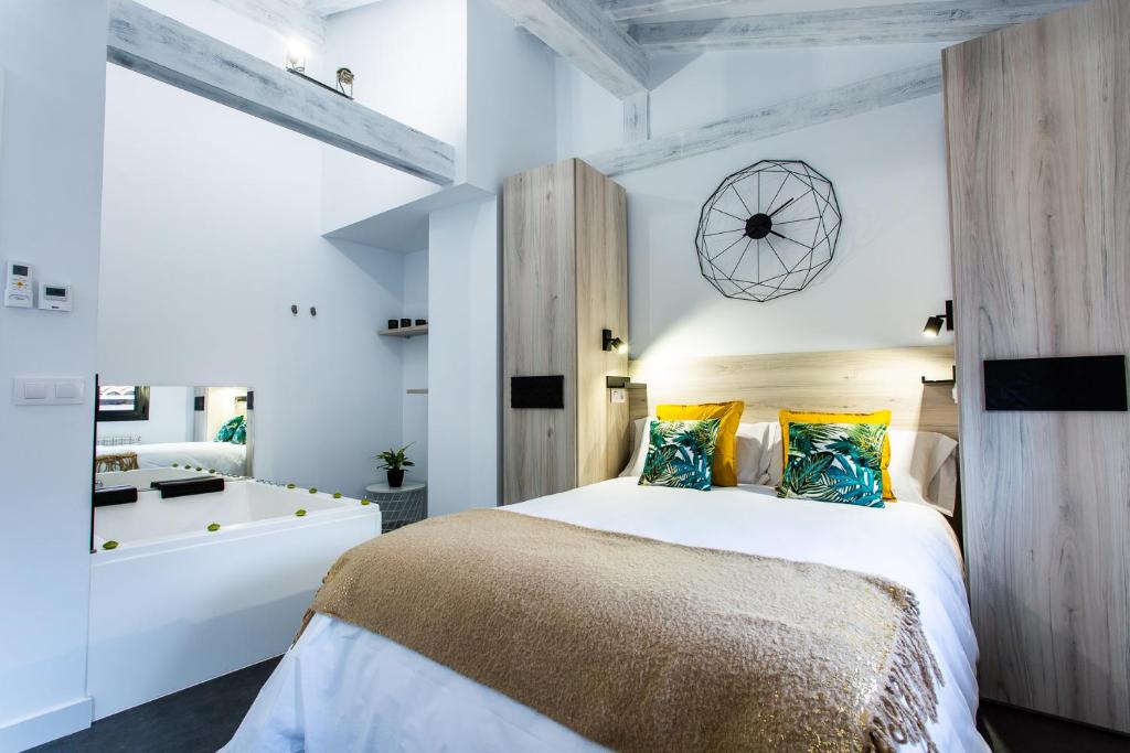 um quarto com uma cama grande e uma casa de banho em Apartamentos Hervás Suites em Hervás