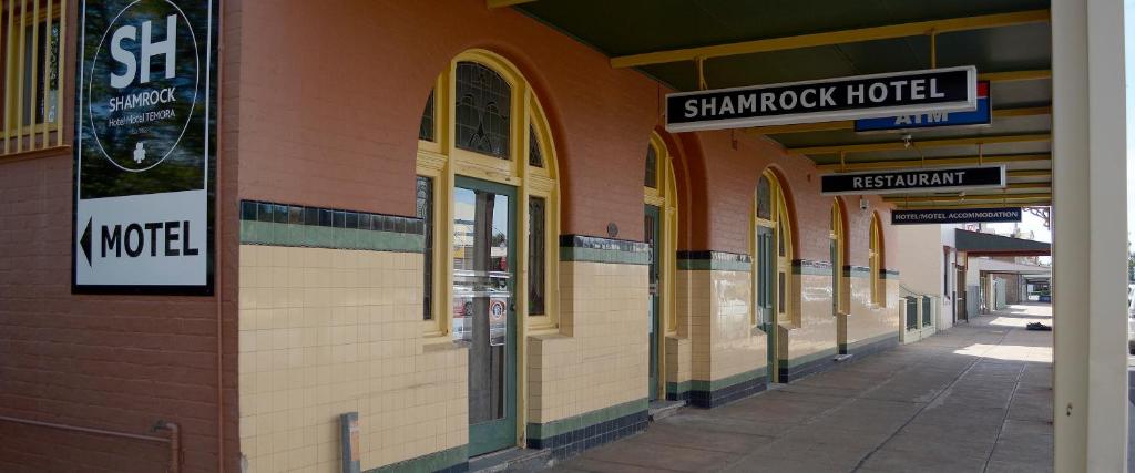 un bâtiment avec des panneaux sur son côté dans l'établissement Shamrock Hotel Motel Temora, à Temora
